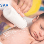 Newborn baby care at home ,baby lying peacefully while powder is gently applied to the skin