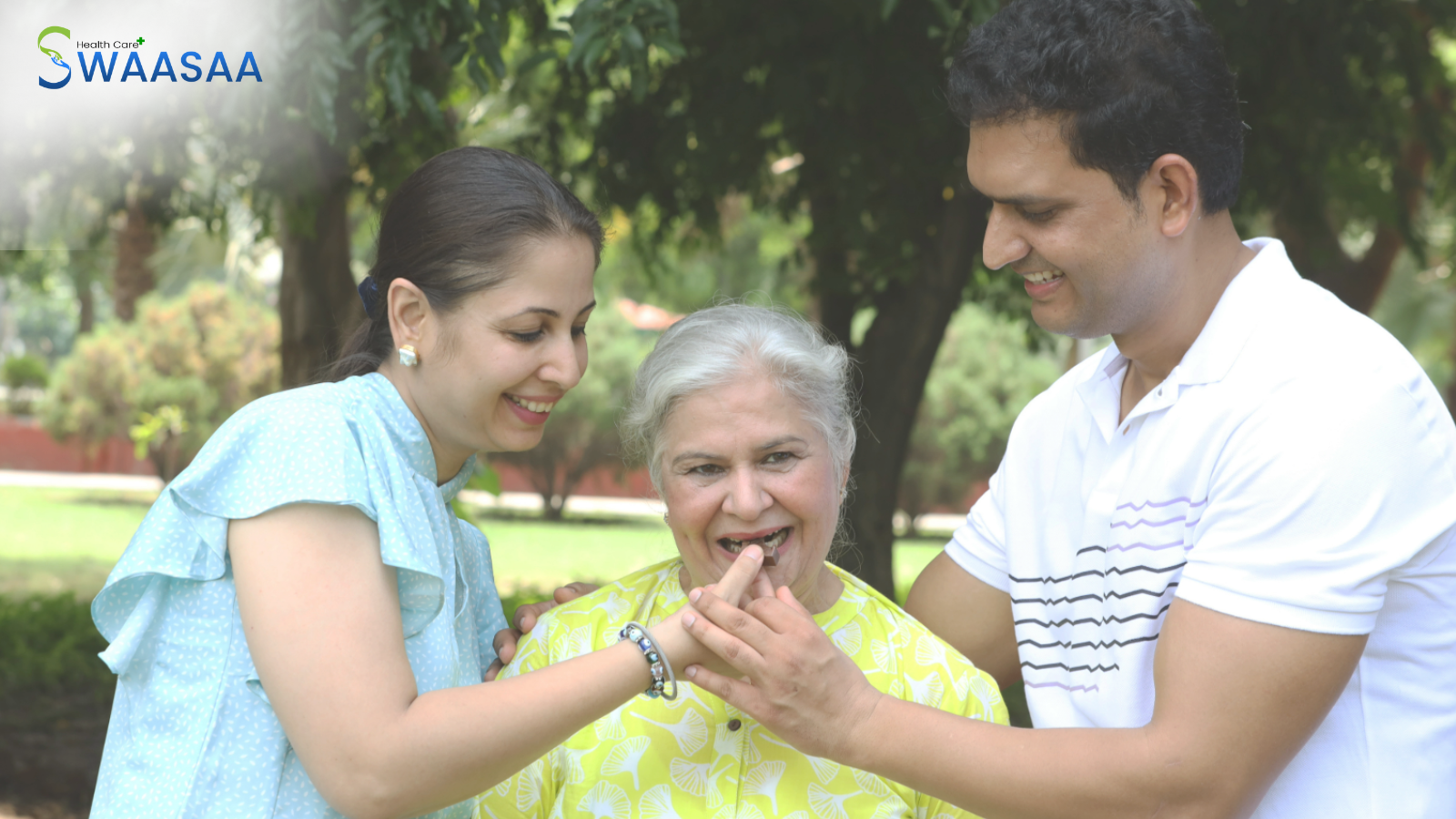 Daughter and son feeding sweets to their smiling elderly mother in a park.
